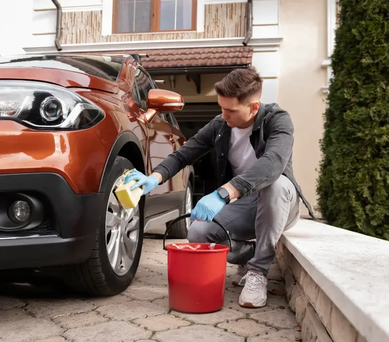 Lavage auto à domicile Hauteville-sur-Mer : professionnel intervenant sur un véhicule